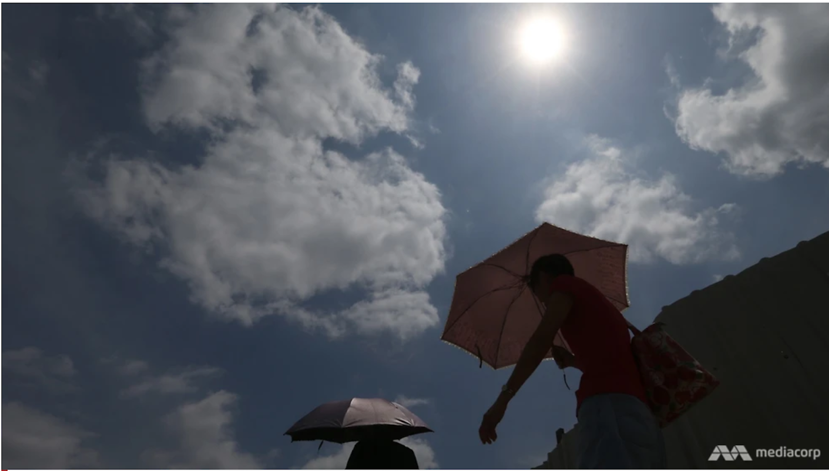 People walk with umbrellas under the hot sun in Singapore. (Credit: CNA; Photo: Ooi Boon Keong/TODAY) &nbsp;