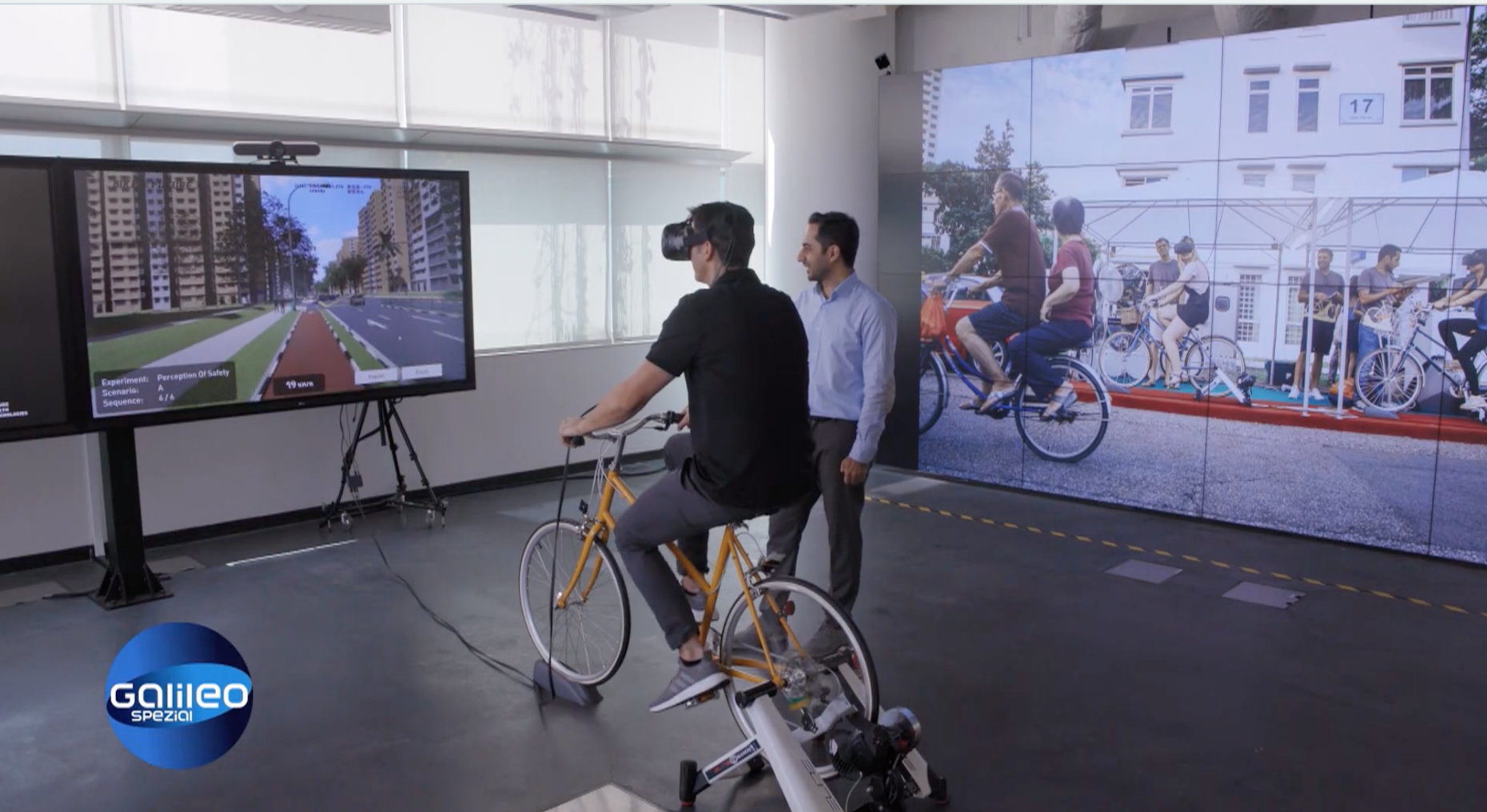 Galileo host Stefan Gödde on the cycling simulator that allows him to &quot;experience&quot; different cycling infrastructure, together with FCL researcher Mohsen Nazemi.