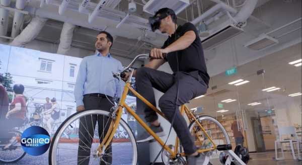 Galileo host Stefan Gödde on the cycling simulator with Future Cities Laboratory researcher Mohsen Nazemi explaining how it works.